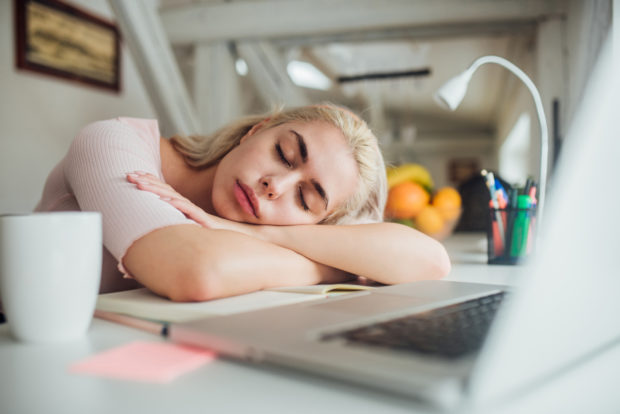 Girl sleeping over her desk